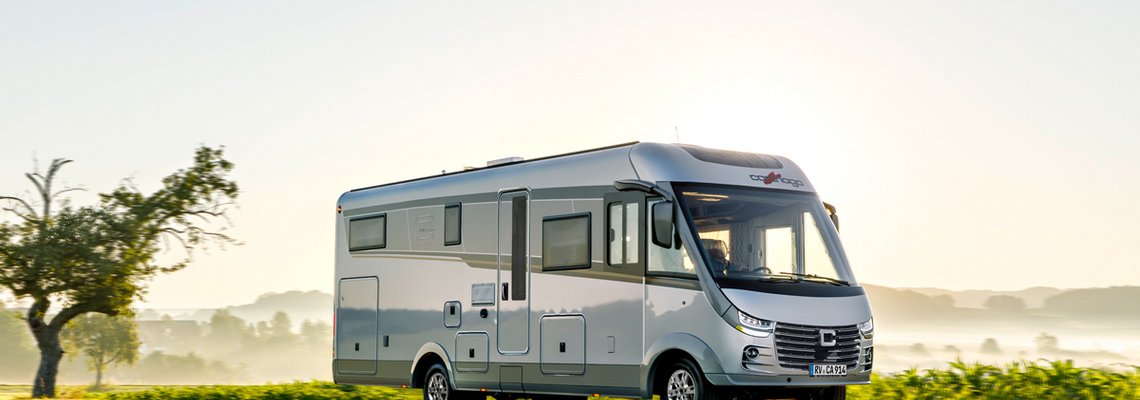Carthago Wohnmobil s-plus auf einer Wiese mit blauem Himmel