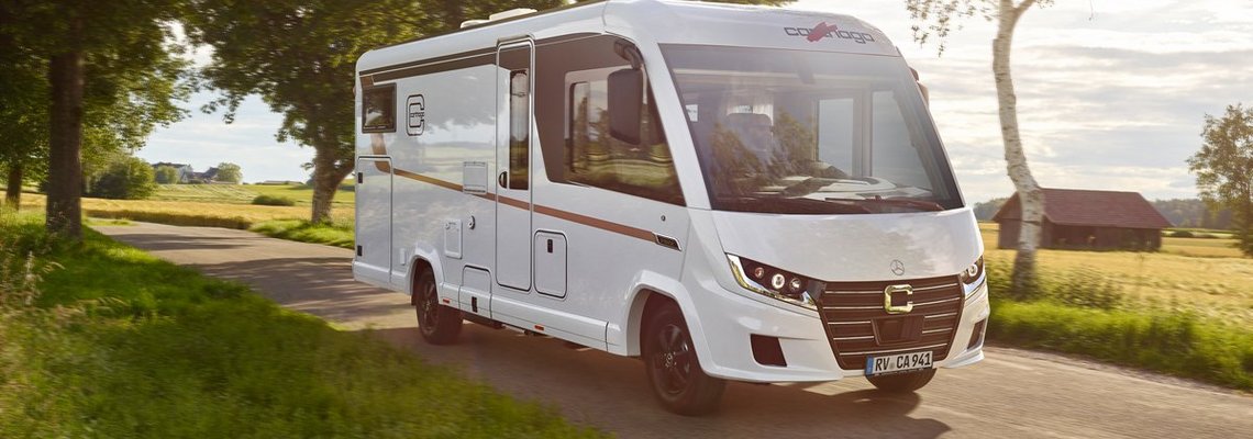 Carthago Wohnmobil C2-tourer auf der Straße, vorbei an Bäumen