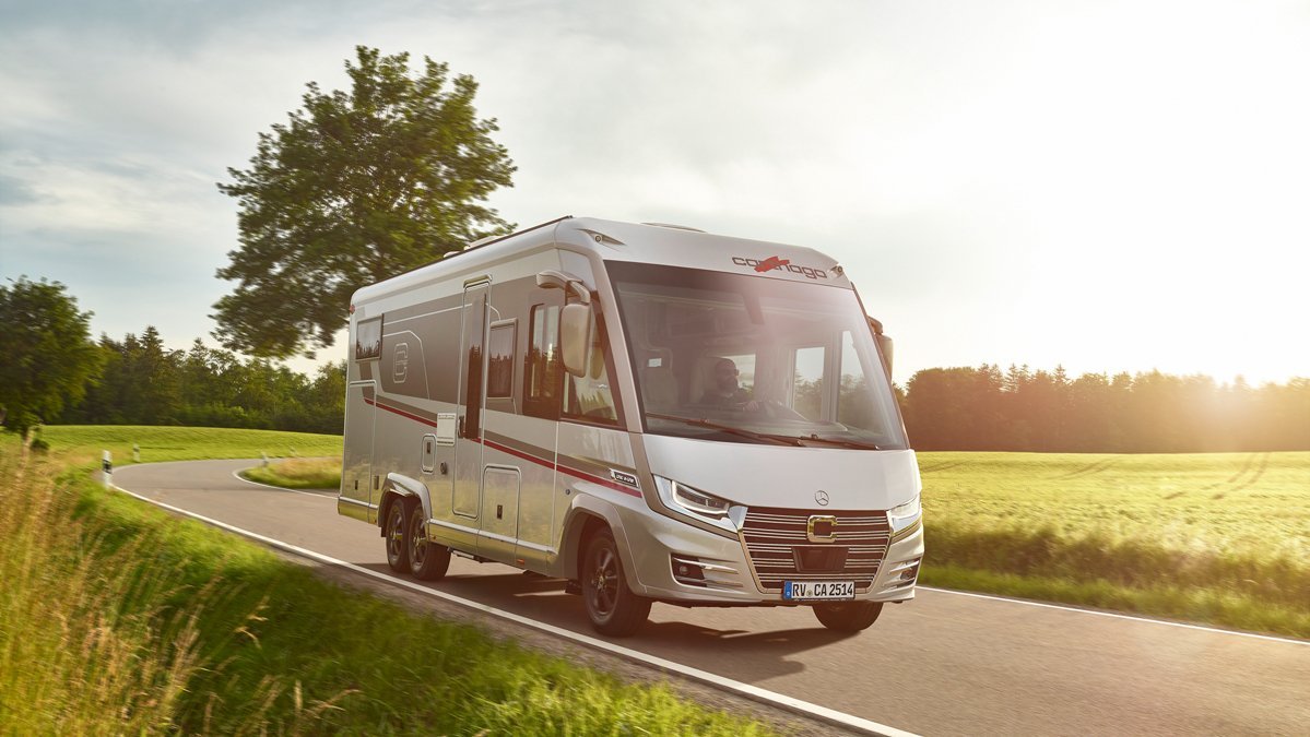 Fahraufnahme Carthago Wohnmobil e-line auf Straße mit Baum im Hintergrund