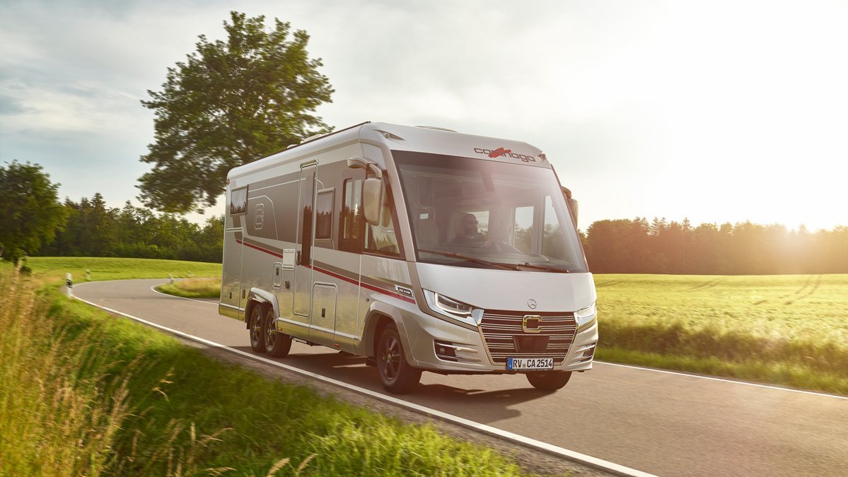 Fahraufnahme Carthago Wohnmobil e-line auf Straße mit Baum im Hintergrund